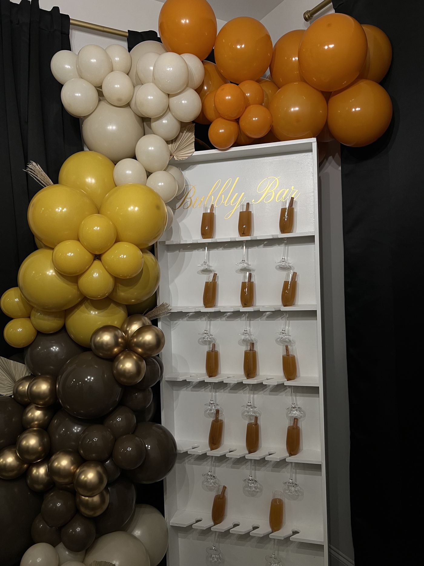 Gold and white balloon garland styled beside a signature drink display